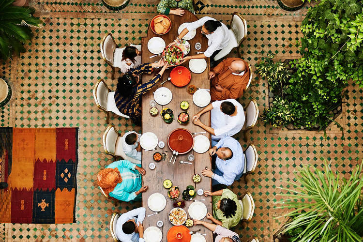 Wide shot overhead view of family gathered at dining room table for multigenerational family dinner celebration