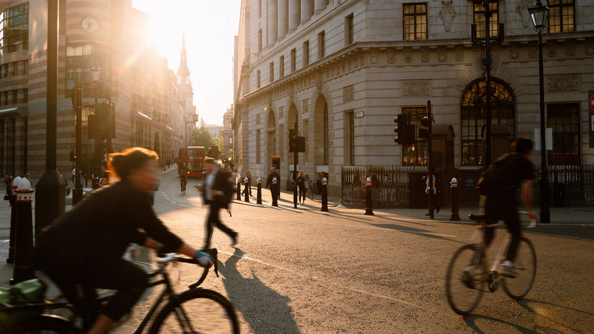A street in London at sunset with cyclists in blurred motion